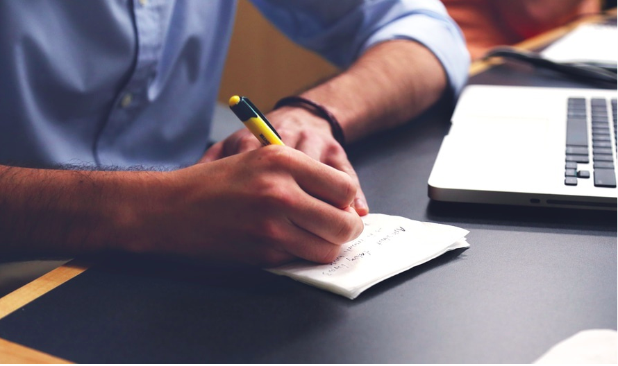 Designer taking notes with pen and paper